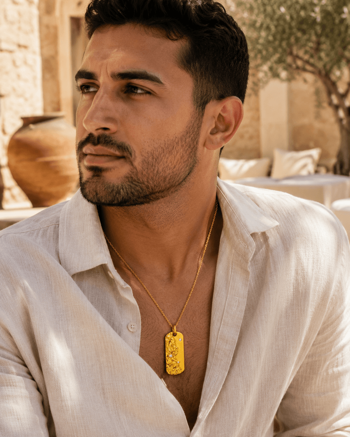 Middle Eastern man wearing the Metal Element Gold Pendant Necklace in a warm lifestyle scene