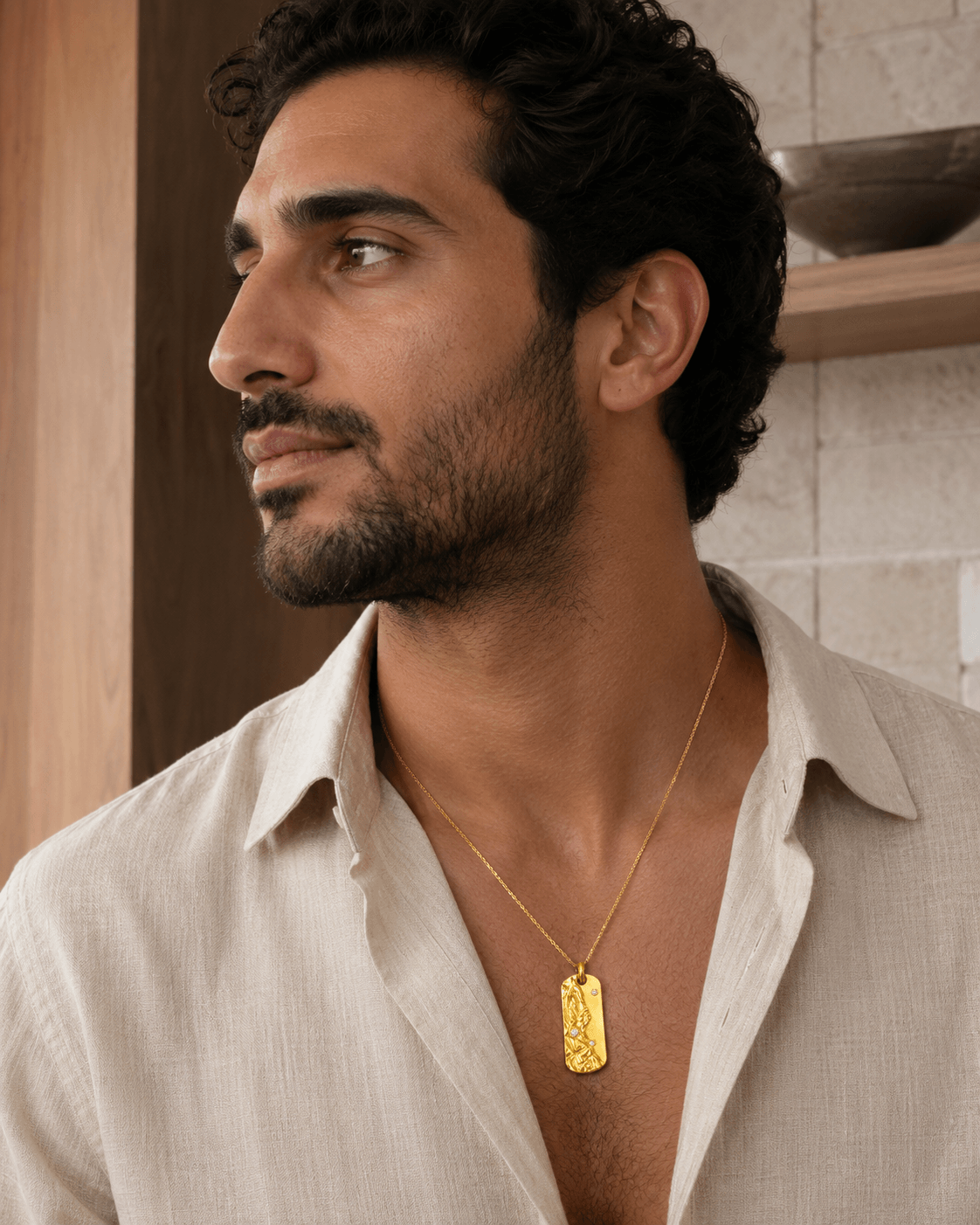Middle Eastern man wearing the Metal Element Gold Pendant Necklace with a linen shirt